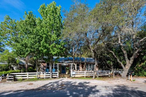 a house with a fence and trees at Artless Sprite in Santa Rosa Beach