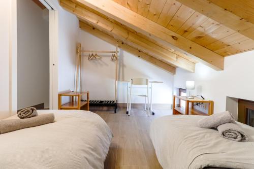 two beds in a room with wooden ceilings at Casanova Apartments - Viewpoint in Vrsar