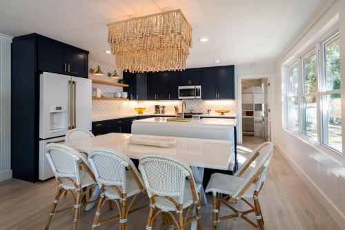 a kitchen with a table and chairs and a chandelier at Artless Sprite in Santa Rosa Beach