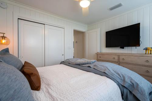 a bedroom with a bed and a flat screen tv at Artless Sprite in Santa Rosa Beach