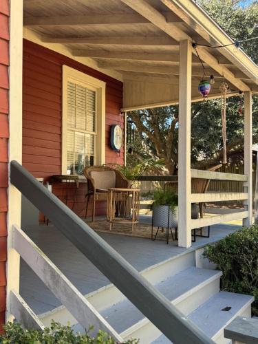 a porch of a house with a table and chairs at Wensel Cottage in downtown Natchez in Natchez