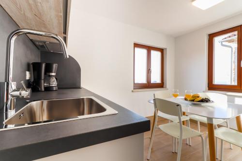 a kitchen with a sink and a table with chairs at Casanova Apartments - Viewpoint in Vrsar