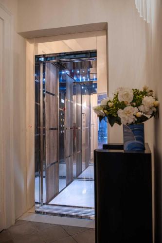 a vase of flowers on a table in front of a glass door at Palazzo Bove 2 - Villa Dagmar in Galatone