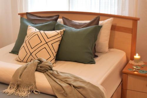 a bed with several pillows and a candle on a table at Villa Sunset in Boghaz