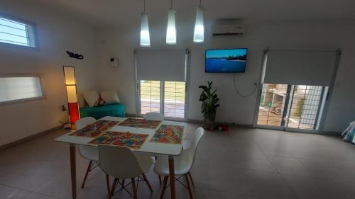 comedor con mesa, sillas y TV en La Casa de Soledad en Paraná