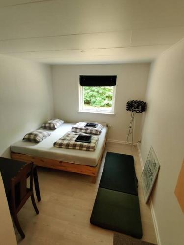 Habitación pequeña con cama y ventana en Nice Little centrum apartment! No.11, en Billund