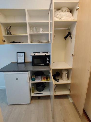 eine Küche mit weißen Schränken und einer Theke mit einer Mikrowelle in der Unterkunft Nice Little centrum apartment! No.11 in Billund