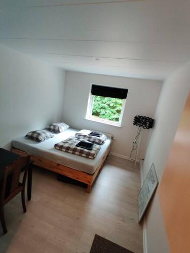 1 dormitorio con 1 cama en una habitación con ventana en Nice Little centrum apartment! No.11, en Billund
