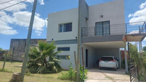 een wit huis met een auto ervoor geparkeerd bij La Casa de Soledad in Paraná