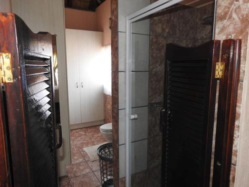 a bathroom with a shower and a toilet in a room at Collin's Rest in Marloth Park