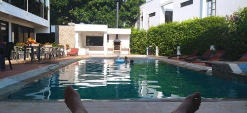 a person laying in a pool with their feet in the water at Villa Campestre Numbana Melgar in Melgar