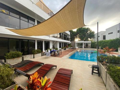a swimming pool in a building with two benches and a swimming pool at Villa Campestre Numbana Melgar in Melgar
