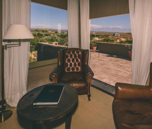 a living room with a chair and a table with a laptop at Rosell Boher Winery Lodge & Spa in Agrelo