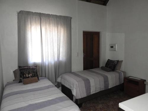 a hotel room with two beds and a window at Collin's Rest in Marloth Park