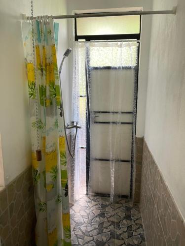 a shower in a bathroom with a shower curtain at Kowlessur Residence in Surinam