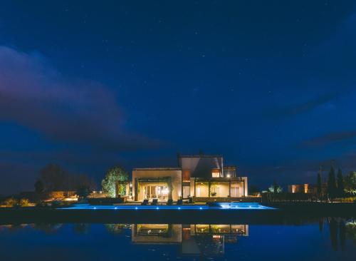 a house in the middle of the water at night at Rosell Boher Winery Lodge & Spa in Agrelo
