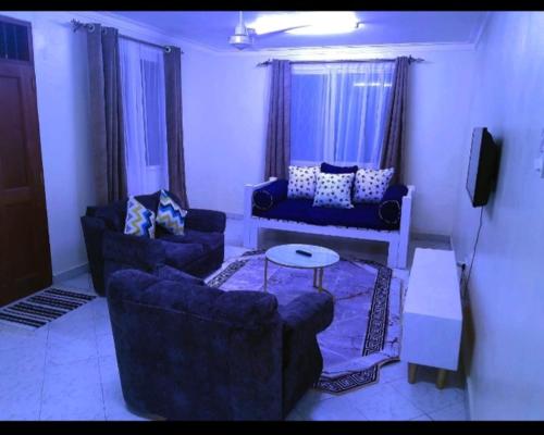 a living room with two couches and a tv at Chloe Isla 2 apartment Malindi in Malindi