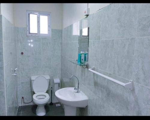 a bathroom with a white toilet and a sink at Chloe Isla 2 apartment Malindi in Malindi