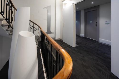 a hallway with a wooden railing and a door at Campanile Annecy Centre - Gare in Annecy