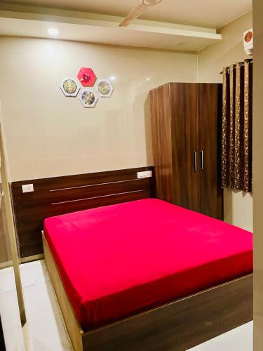 埃爾納古勒姆的住宿－Meridian Regency，一间卧室配有红色的床和木制橱柜