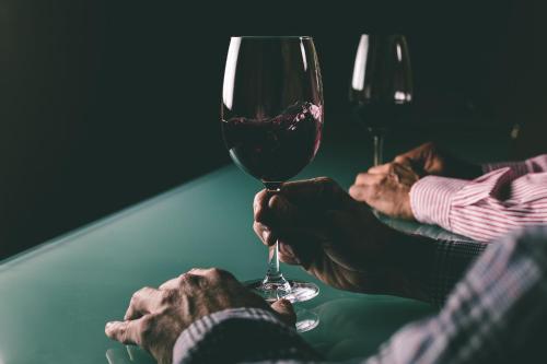 a person holding a glass of wine on a table at Rosell Boher Winery Lodge & Spa in Agrelo