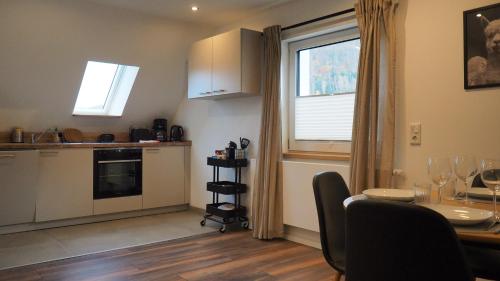 une cuisine avec une table et une fenêtre ainsi qu'une salle à manger dans l'établissement Ferienwohnung am Okertal, à Goslar