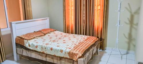 a small bed in a room with a curtain at Kapowlito Real Estate Casa #1 Mon Plaisirweg in Paramaribo