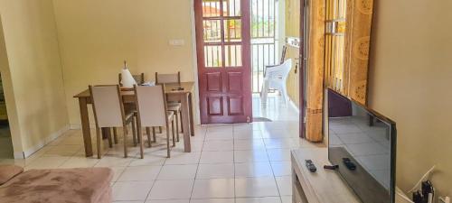 a dining room with a table and a red door at Kapowlito Real Estate Casa #1 Mon Plaisirweg in Paramaribo