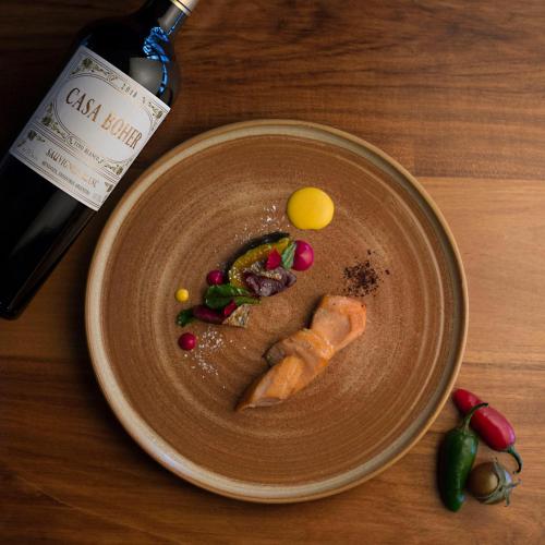 a plate of food with vegetables and a bottle of wine at Rosell Boher Winery Lodge & Spa in Agrelo