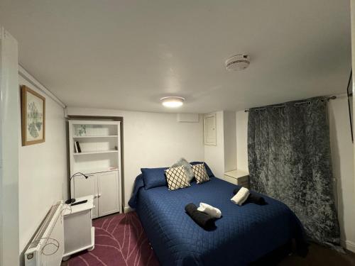 ein Schlafzimmer mit einem blauen Bett mit zwei Handtüchern darauf in der Unterkunft Comfortable Modern Home, Self Catering Flat, Newly refurbished, town centre, free parking in Cheltenham