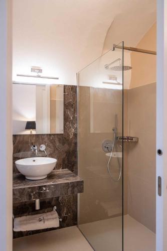 a bathroom with a sink and a glass shower at Palazzo Bove 2 - Villa Dagmar in Galatone