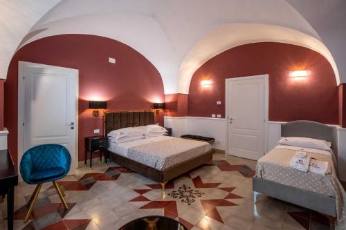 a bedroom with two beds and a table and a chair at Palazzo Bove 2 - Villa Dagmar in Galatone