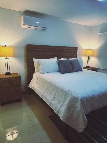 a bedroom with a large bed with two lamps at Newly renovated ! Villa Laguna Cancun in Cancún