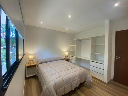 a bedroom with a bed and a large window at Ubatuba Lofts Mar Azul - depto 2 hab in Mar Azul