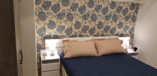 a bedroom with a blue bed with a floral wallpaper at A viuzza in Cefalù
