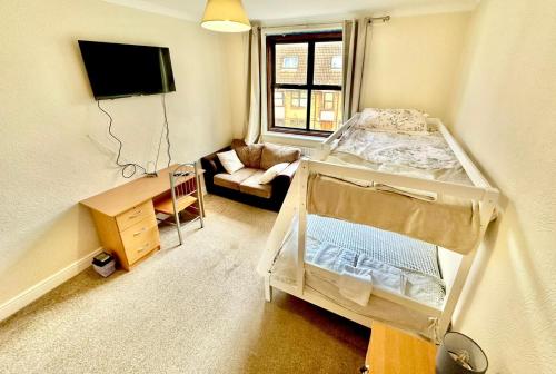 a small room with a bed and a couch at Stay in Whitechapel apartment in London