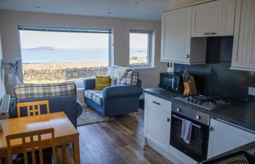 a kitchen and living room with a view of the ocean at Solas Alainn Chalet in Portree
