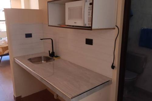 a small kitchen with a sink and a microwave at Mono ambiente nuevo completo 3 in Sucre