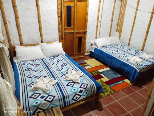 パストにあるACUARELA TURÍSTICO Y CAMPESTREのベッド2台が隣同士に設置された部屋です。