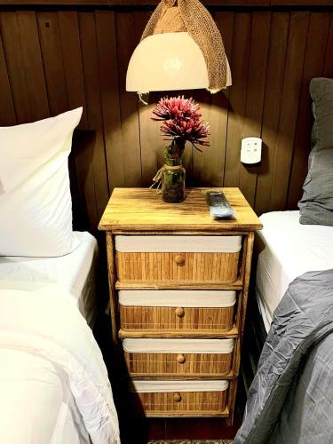 a nightstand with a plant on it next to two beds at Apartamento Casa Antigua in Santa Ana