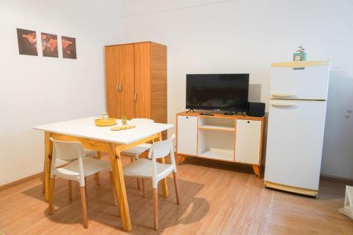 a small kitchen with a table and a refrigerator at Solar del Tajamar in Alta Gracia