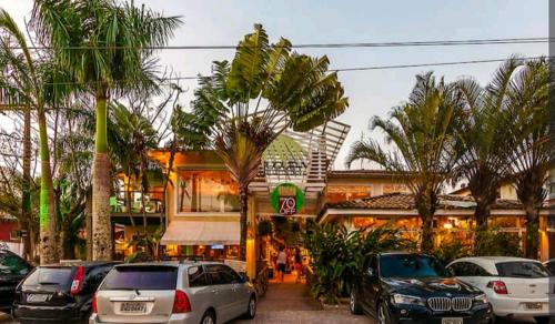 a parking lot with cars parked in front of a building at Flat charmoso na praia de Juquehy in São Sebastião
