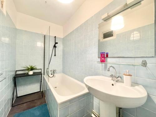 une salle de bain blanche avec un lavabo et une baignoire dans l'établissement LA PASSERELLE 1D - Quartier Gare - Wifi, à Quimper