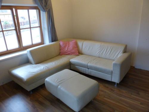 a living room with a couch and a ottoman at Tannenzapfen in Auffach