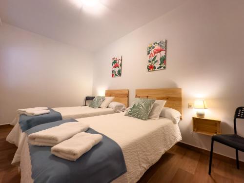 a room with two beds and a chair at Casa Rural Claudia in Puigmoreno