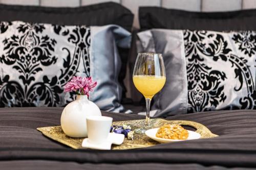 大特爾諾沃的住宿－LUXIMO ROOM，床上一杯葡萄酒和一盘食物