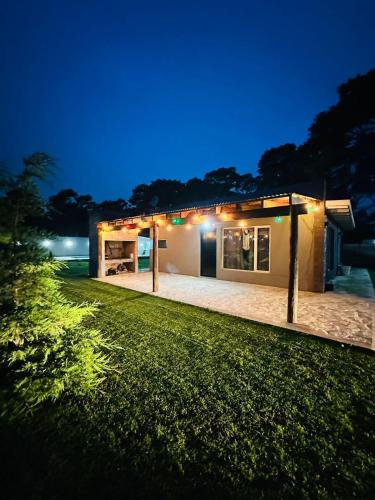 a house with a lawn in front of it at night at Cabaña en Villa del Deportista Villa Shalom in Necochea