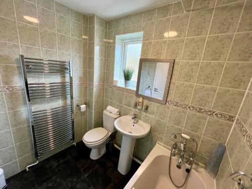 łazienka z toaletą, umywalką i wanną w obiekcie Middleton House w mieście Norwich
