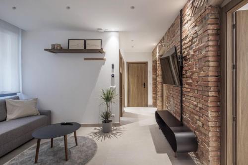 a living room with a couch and a brick wall at Luxury flats PCL by Clabao in Logroño