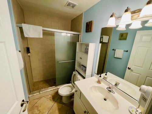 W łazience znajduje się umywalka, toaleta i prysznic. w obiekcie Beach Condo with Game Room Steps To Beach w mieście Clearwater Beach